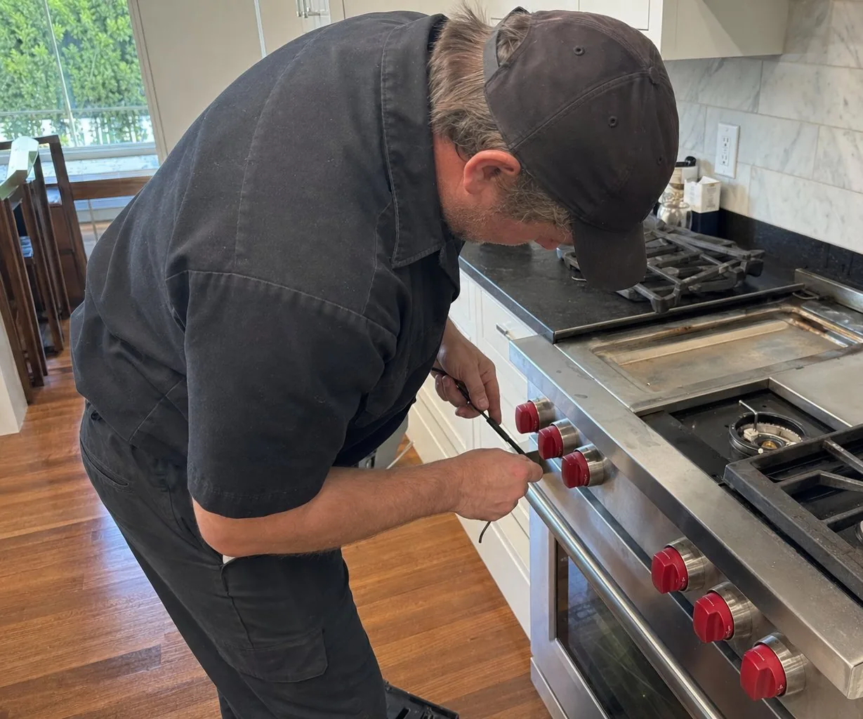 Technician servicing a stainless Wolf range